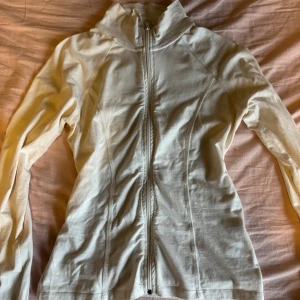 Vit zip-jacka från Gina Tricot - Vit/Kräm vit träningsjacka från Gina tricot. Har tyvärr blivit för stor för mig men passar perfekt till dig som är mellan S och M i storlek. Skriv gärna om ni har andra förslag på pris💞