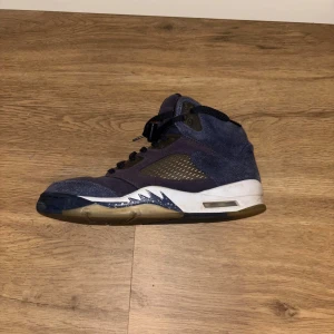 Jordan 5s Mocca  - Säljer ett par Nike Air Jordan 5 Retro i mörkblå mocka med svarta detaljer och vit sula. Skorna har klassisk Jumpman-logga på plösen och hälen. Finns tecken på användning men rätt så fina
