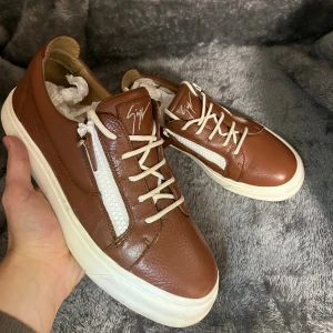 Snygga Bruna  Giuseppe Zanotti skor - Snygga bruna sneakers från Giuseppe Zanotti i  skinn, använda men i grymt bra skick! Inget og tillkommer! Skriv till mig vid frågor eller liknande! Priset är icke hugget i sten, kan diskuteras vid snabb och problemfritt köp!