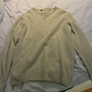 Beige stickad tröja med rund hals - Mysig beige kasmhir tröja med rund halsringning och ribbade muddar vid ärmslut och nederkant. Perfekt för lager-på-lager och passar till både jeans och kjol. Enkel och stilren design som funkar året runt.