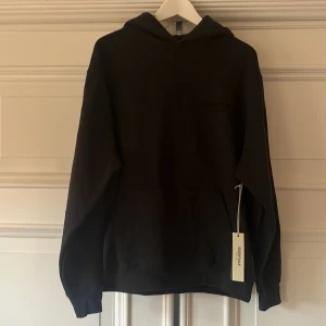 Essentials hoodie  - Svart hoodie från Essentials Fear of God med stor logga på ryggen och mindre logga på bröstet. Tröjan är självklart autentisk och extremt snygg. Vid minsta fundering så är det bara att skriva.