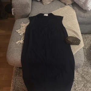 Marinblå ärmlös klänning Holly & Whyte - Snygg marinblå ärmlös klänning från Holly & Whyte by Lindex. Enkel och stilren design med rak passform och diskret v-ringning. Perfekt för dig som gillar minimalistisk stil och vill ha en klänning som känns både klassisk och modern.