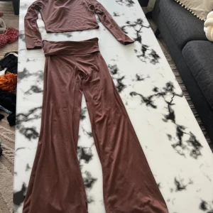 Bruna vida mjukisbyxor - Säljer ett par bruna mjukisbyxor med riktigt vida ben och hög midja. Byxorna är gjorda i ett mjukt och stretchigt material som känns skönt mot huden. Perfekta för en chill dag hemma eller när du vill ha något bekvämt men ändå snyggt.