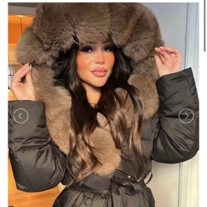 Svart pälsjacka  - Säljer en svart lång dunjacka med en riktigt maffig och fluffig brun räv päls. Jackan har bälte i midjan. Helt ny, aldrig använd. Inköpt för 3499:- säljer för 1499:- då jag bara vill bli av med den. Jackan är köpt på luxeswe.com