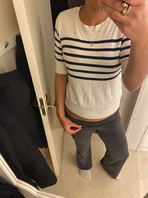 Vit randig tröja från Kappahl - Vit tröja från Kappahl i storlek S med mörkblå  ränder. Modellen har rund hals, korta ärmar och ribbad kant nedtill. Materialet är mjukt och känns som bomull, perfekt för vår och sommar. 