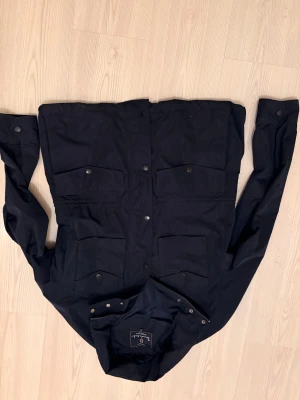 Bondelid Gerard field jacket DARK NAVY - Bara använd en gång och i fint skick. Ett av spännena har lossnat, men det är en liten och lättfixad detalj som inte påverkar funktionen i övrigt