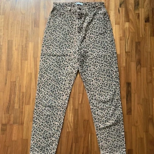 Leopardmönstrade jeans  - Snygga jeans från Gina Tricot i beige/brunt med svart leopardmönster. Modellen har bälteshällor, perfekt till skärp. Byxorna är i fint skick. 