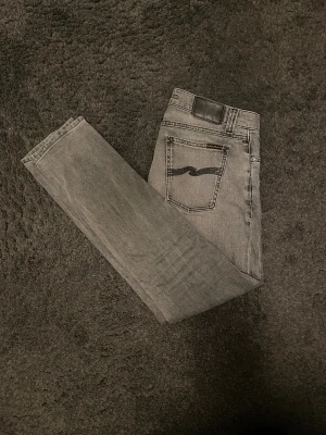 Nudie jeans - Säljer mina nudie jeans då dem blivit för små. Dem är ljusgrå och i storlek W30 L30. Modellen heter Lean Dean. Byxorna är bra skick utöver ett hål i vänsterfickan. Skriv vid fler funderingar!🙌🏼