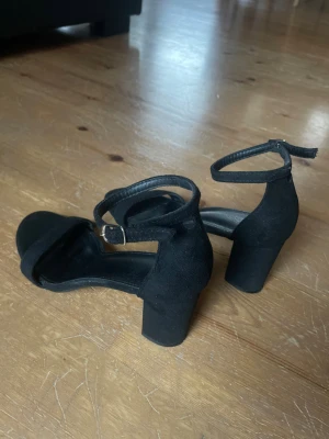 Svarta klackar med mocka  - Svarta klack skor med mocka och falskt skinn. Bandet runt ankeln har flera hål att välja mellan när det gäller storlek. Min sko storlek är 37/38 men dessa klackar hade även funkat för dig som har storlek 36. Endast använda en gång men har inte längre någon användning för dom!😊💕