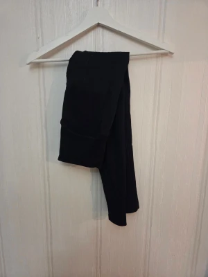 Svarta ribbade tights från Stronger - Svarta ribbade tights från Stronger med tjock resår i midjan. Sparsamt använda, stl S. Djur finns i hemmet aä kan förekomma lite hårstrån