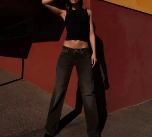 Svart croppad ribbad linnetopp från Zara  - Säljer en svart croppad linnetopp med ribbad struktur och rund hals. Toppen är ärmlös och sitter tight mot kroppen, perfekt för dig som gillar en enkel men snygg look. Passar till både jeans och kjol och är lätt att matcha med andra plagg.