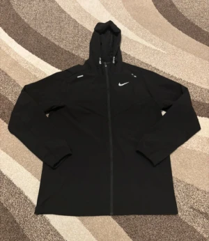 Nike svart vindjacka/springjacka - Säljer denna vindjacka/springjacka då den är för stor mig. Den är helt nya och aldrig använd och är super sköna att ha på sig. Vid frågor är de bara att skriva.