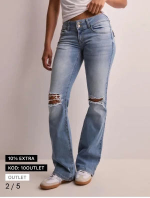 Bootcut ljusblå jeans med slitningar - Snygga ljusblå bootcut jeans med slitna detaljer och hål vid knäna. Dom är använda ett fåtal gånger och är i bra skick, har flera bilder så skriv för att få det. Köpta i somras för 700kr. Är som en 36/38 i storlek.