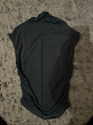 Tajt tröja från Gina tricot - Säljer min tajta tröja som är sydd på sidan, den har halva ärmar och en liten polo krage. Den är grå med lila nyanser.