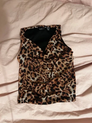 Fest topp🤩🤎 - En snygg leopardmönstrad topp som passar till allt! Går bra att ha både till fest och vardag. Storlek XS men passar säkert S med. Mycket bra skick💕 PS: Köp gärna med instabox, skickar snabbare då🥰