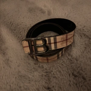 B bälte - Snyggt bälte från b@rberry. Kan inte garantera äkthet. Lite slitet några extra hål på den och även på den som håller B et. Fraktas inom 48 timmar