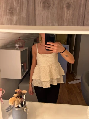 Vit topp - En vit topp från gina tricot den är aldrig använd. Den har volanger nertill. Storlek s