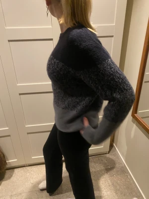 Mörkgrå stickad tröja från InWear - Säljer en snygg stickad tröja från InWear i mörkgrå och ljusgrå toner. Tröjan har ett randigt mönster med melerade detaljer och rund hals. Den är långärmad och har en mjuk, fluffig känsla som gör den perfekt för vintern. Modellen är 175cm💞 använd 1-2 gånger. Nypris: 800kr