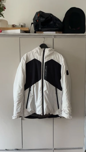 Sail racing jacka  - Sail racing jacka i stl M herr  BESKRIVNING – Svart dunjacka från Sail Racing. Stängs framtill med dragkedja. Två bröstfickor och två framfickor som stängs med dragkedja. En innerficka som stängs med dragkedja. Broderad logotyp på vänster bröst och bak på luvan, patch med logotyp på vänster ärm. Luva med dragsko. Justerbara ärmslut. Jackan är vind och vattenavvisande. ■PFC-fritt DWR membran ■ 70/30 blue sign RDS certifierat dun Skriv för fler bilder! – Köptes för 4,5 k JACKAN ÄR I NYSKICK❤️‍🔥