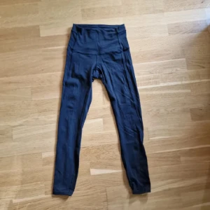 Lululemon - Lululemon, 25", stlk 4, hög midja, svarta med detalj i anklar. Lite tjockare tyg som stannar på plats. Använda och lätt noppriga i ljumsken (av ca 3 års användande) , men de har några år kvar i grenen 🐈‍⬛