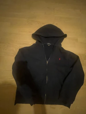 Ralph lauren zip hoodie - Säljer en mörkblå hoodie från Ralph lauren i bra skick, storleken stämmer inte riktigt, det står 18-20 år i men jag uppfattar det som cirka storlek xs eftersom att jag är ca 165 och den passar perfekt.