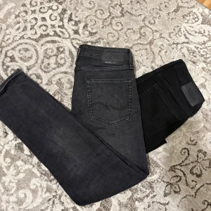 Jack & Jones svarta och grå jeans - Säljer två par riktigt feta jeans från jack & jones, båda är i storlek W28 L32. Den svarta är i modelen slim glenn och dem är i modelen tapered/mike, alltså sitter båda slim fit.