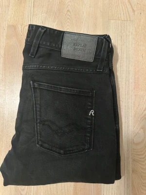 Replay svarta jeans - Svarta jeans från Replay med klassisk femficksdesign och snygg Replay-logga på bakfickan. Ambass modellen med normal midja och raka ben. Jeansen är tillverkade i mjukt denim-material som sitter skönt och har en stilren look. Storlek 29:32. Hör av vid frågor eller ytligare bilder! 