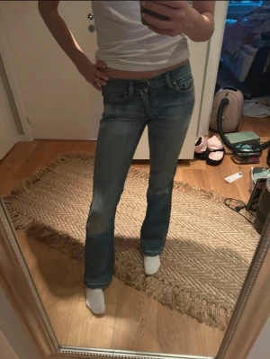 Blå bootcut jeans från Diesel, stl 25 - Snygga blå jeans från Diesel i bootcut-modell med låg midja. Jeansen har klassisk femficksdesign, slitningar på bakfickan och är tillverkade i mjukt denim. Perfekta för dig som gillar en avslappnad men trendig look.