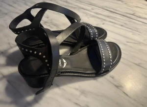 Svarta sandaler med klack o nitar från Zadig & Voltaire - Snygga svarta klackar från Zadig & Voltaire med coola silverfärgade nitar på remmarna. Skorna har en låg klack (4 cm) är tillverkade i äkta skinn!! Skickar snabbt🩵🩵🩵🩵