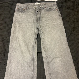 Grå raka jeans från Gina - Snygga grå jeans från Gina med klassisk femficksdesign och raka ben. Jeansen har en silverfärgad knapp och dragkedja i gylfen. Perfekt för dig som gillar en enkel och stilren look. Materialet är robust denim i bomull.