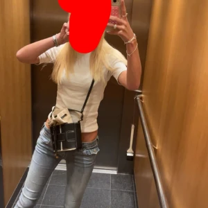 Svart och beige bucket bag från hm - Trendig bucket bag från hm i svart skinn och beige canvas som inte säljs längre. Väskan har snygga kontrastsömmar, justerbar axelrem och cool snörning upptill. Perfekt storlek för mobilen och det viktigaste. Snygg och stilren design som lyfter varje outfit.