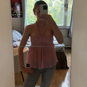 Rosa halterneck linnetopp - Säljer en populär rosa linnetopp med halterneck och twistad detalj framtill. Köpt på Plick
