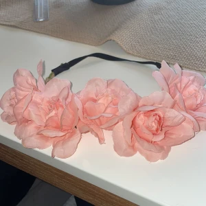 Hårband med rosa blommor - Perfekt för midsommar eller festival! Elastiskt band baktill för skön passform.