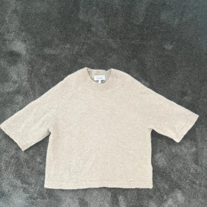 Beige stickad tröja från & Other Stories - Säljer en supermjuk beige stickad tröja från & Other Stories med rund halsringning och halvkort ärm. Jag har aldrig använt den men köpte den av en annan person här på appen som knappt hade använt den så den fortfarande är jättemjuk och fin💕💕