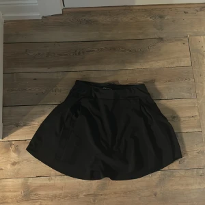 Svart kortkjol från fs sports  - En svart kortkjol från Esprit med enkel och stilren design. Kjolen har en lätt utställd form och bred linning, vilket ger en snygg siluett. Perfekt att matcha med en cool topp eller hoodie.