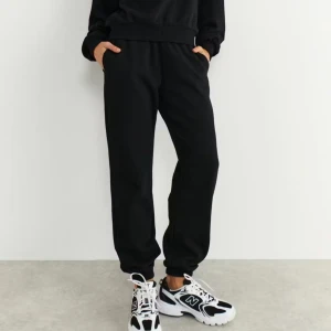 Gina Tricot Basic Sweatpants - Svarta mjukisbyxor med elastisk midja och muddar vid bensluten. Byxorna har en avslappnad passform och är tillverkade i mjukt bomullsmaterial. Perfekta för chill dagar eller när du vill vara extra bekväm.