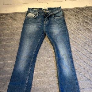 Blå jeans från 365, storlek 27 - Snygga blå jeans från 365 i klassisk femficksmodell. Jeansen har en mellanblå tvätt med lätt slitning och raka ben. De är tillverkade i jeanstyg och har en normal passform. Perfekta för dig som gillar en enkel och stilren look.
