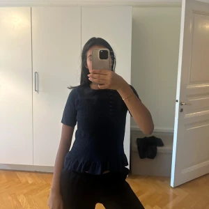 Mörkblå topp med volangkant - Supersöt mörkblå topp med korta ärmar och volangkant nertill😊