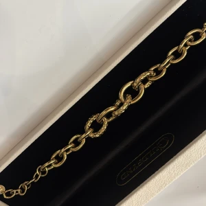 Guldfärgat armband från Guldfynd - Stilrent guldfärgat armband från Guldfynd med chunky kedjelänkar. Vissa länkar har en snygg hamrad textur som ger extra edge. Perfekt statement-piece för dig som gillar att sticka ut med accessoarerna.