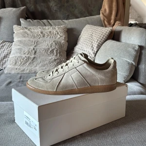 Maison Margiela gats - Ett par sällsynta sneakers från maison margiela! Väldigt bra skick men såklart lite defekter tex lite lite slitage på sulan, du får med box, dust bag. De är i en beige färg och gjorda i mocha om du vill veta något eller ha fler bilder får du gärna höra av dig!! Oj juste storlek 42 men passar 42,5 och 43… tar också byten om du har något roligt du vill byta.  Ny pris: 5499kr Mitt pris: 3500