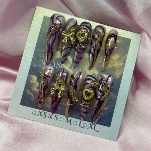 RoyalAmethyst (S);Extra Long Stiletto;Curved - Supercoola press-on naglar i lila och guld med 3D-detaljer som fjärilar, kedjor och hjärtan. Naglarna är långa och spetsiga med glittrig finish och swirl-mönster. Perfekt för dig som vill sticka ut med en unik och lyxig nagelstil.