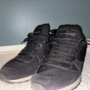 Alexander McQueen - Säljer dessa otroligt unika sneakers från Alexander McQueen med ovandel i mesh och skinn. Skorna har klassisk snörning, rund tå och platt sula. Perfekta för dig som gillar stilrena och exklusiva sneakers med en sportig vibe.