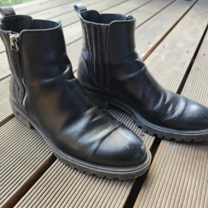 Svarta boots från Esprit i skinn - Snygga svarta boots från Esprit i äkta skinn med grov sula och dragkedja på sidan. Klassisk rund tå och robust design som passar perfekt till höst och vinter. Bootsens stilrena look gör dem lätta att matcha med olika outfits.