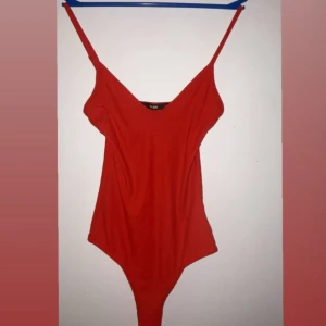 Röd ribbad linnebody från Bik Bok - Säljer en röd ribbad linnebody från Bik Bok i storlek XS. Den har smala axelband, v-ringning och ärmlös design. Perfekt att styla med jeans eller kjol för en snygg look.