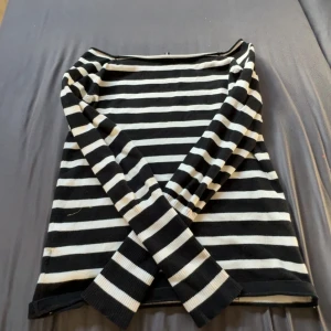 Randig svartvit tröja - Svart och vit randig långärmad tröja från Fishbone. Tröjan har en klassisk båtringad hals och är tillverkad i mjukt bomullsmaterial. Perfekt för dig som gillar en enkel men stilren look med tydliga kontraster.