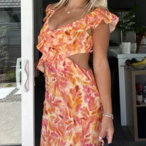 Blommig långklänning med volang och cut-out - Säljer nu min absoluta favorit långklänning från Zara i färgstarkt mönster med orange, rosa och gula toner. Den är perfekt för sommarens alla tillfällen! Inga defekter alls!! (Inte alls många som säljer denna klänning så passa på att köpa) (Pris går att diskutera vid snabb affär)!