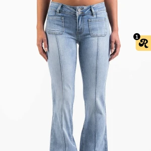 Ljusblå bootcut jeans med fickor - Säljer ett par ljusblå jeans med bootcut-modell och markerade sömmar framtill. Jeansen har stora fyrkantiga fickor fram och bakfickor med lock och knapp. Snygg passform med låg midja och tillverkade i klassiskt denimtyg. De har storlek 34/short. Lägg prisförslag om du är intresserad!
