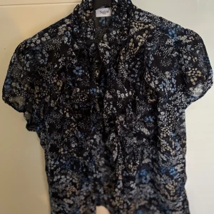 Fin blus från Saint Tropez - Säljer min blus från Saint Tropez med volanger framtill. Marinblå med blommönster.Endast använd vid några tillfällen, därför i mycket bra skick.