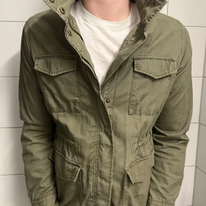 Olivgrön Fieldjacket från Dobber - Säljer denna feta fieldjacket från Dobber 🙌Jackan är riktigt stilren med fordrade armar som håller värmen, perfekt för dig som vill ha en avslappnad look nu till hösten 🍂