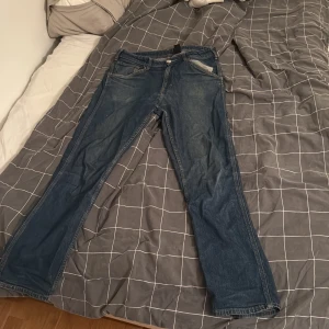 Blå straight jeans från H&M - Säljer ett par klassiska blå jeans från H&M med straight fit. Jeansen har några trådar som sticker ut men hela, andvända mycket men är i bra skick, pris går att diskuta:)